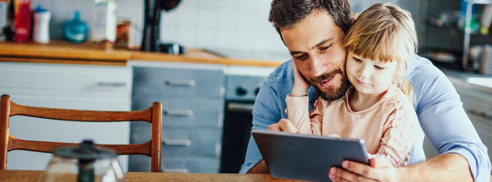 a father and daughter looking at a tablet