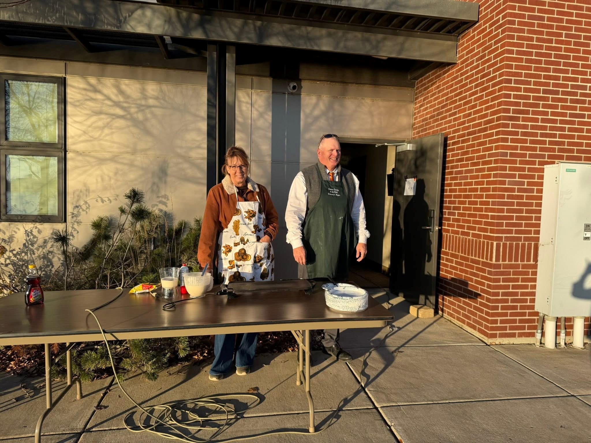 Board Member Karen Wang and President Dean Wang cooking pancakes for the Bank employees outside of the Bank.