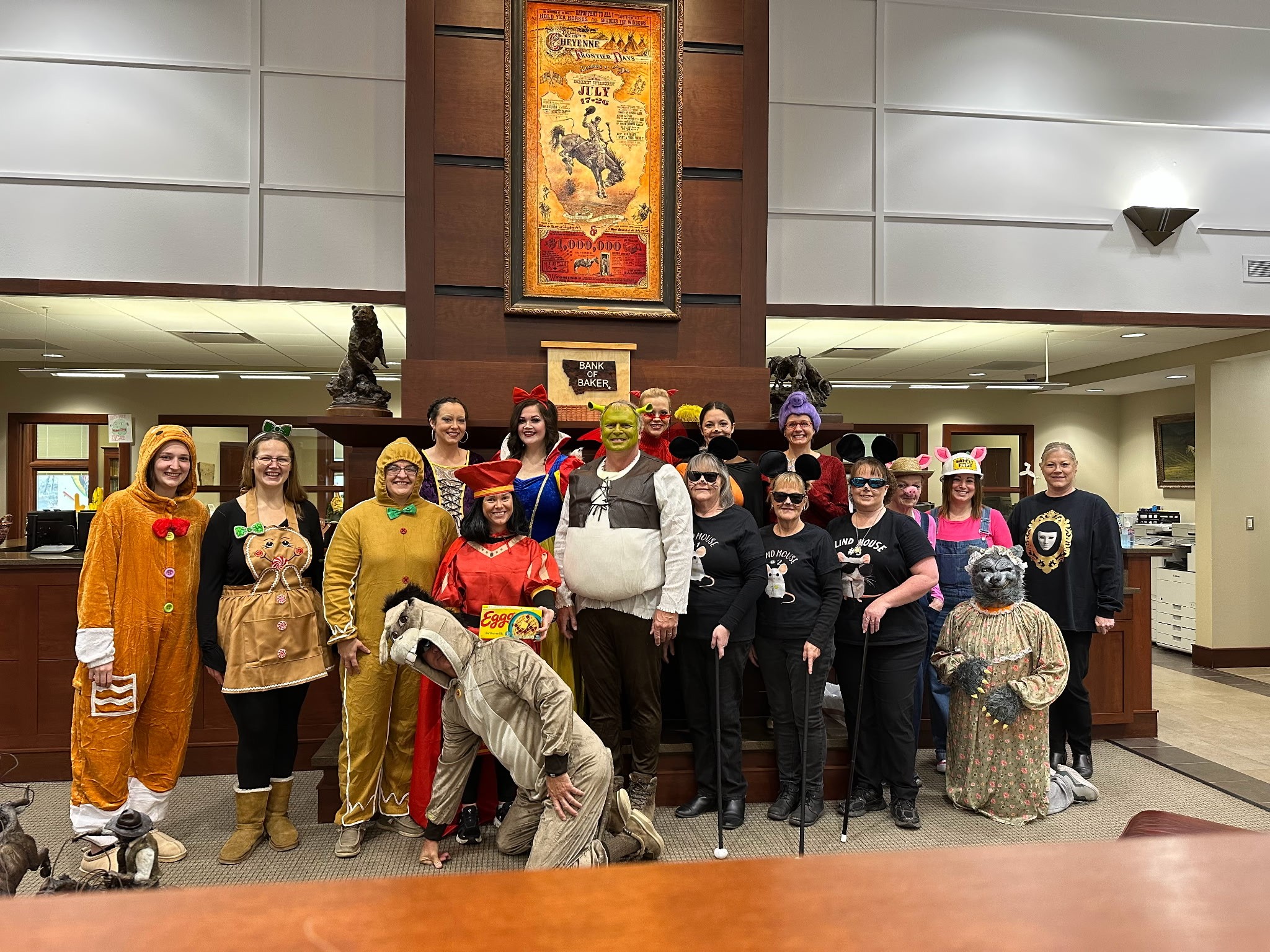 The staff of the Bank of Baker dressed as an assortment of characters from the movie Shrek. Including but not limited to Shrek, Donkey, Lord Farquad, the Gingerbread Men, the Fairy God Mother.